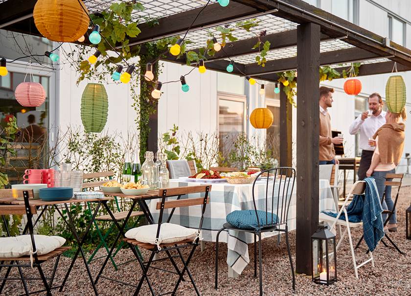 Folk samlade under en pergola som är festligt pyntad